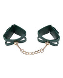 BB Store emerald green faux leather cuffs with cutout detail and gold chain. Adjustable buckle closure.